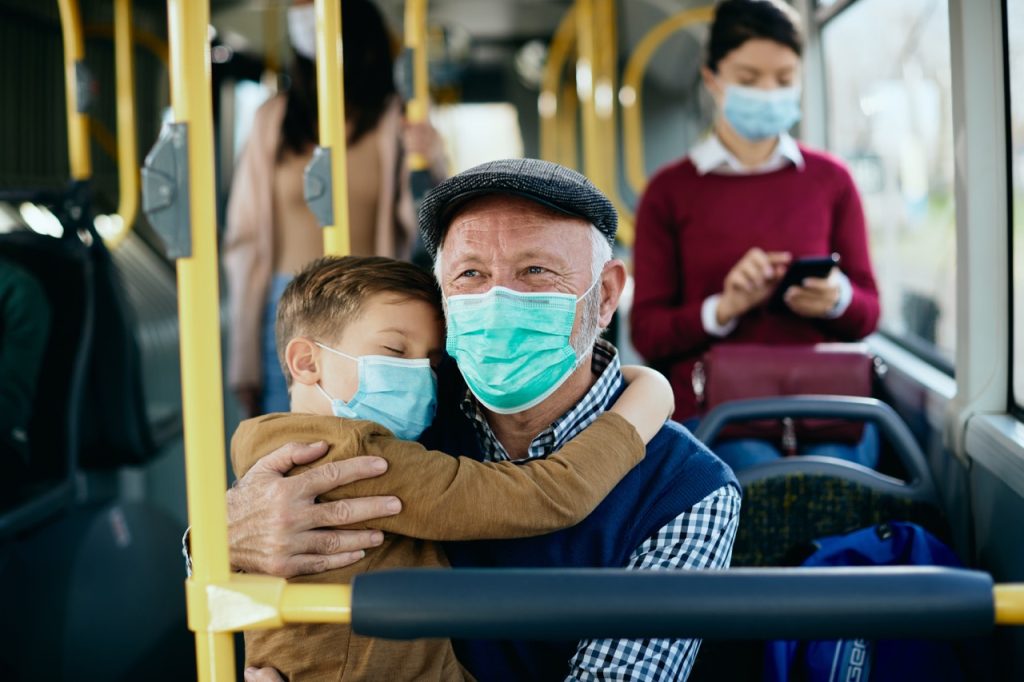 Anciano y niño en autobús de linecar Fin mascarillas